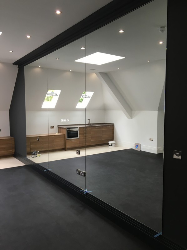 Frameless glass partition in loft conversion by St John's Wood glaziers